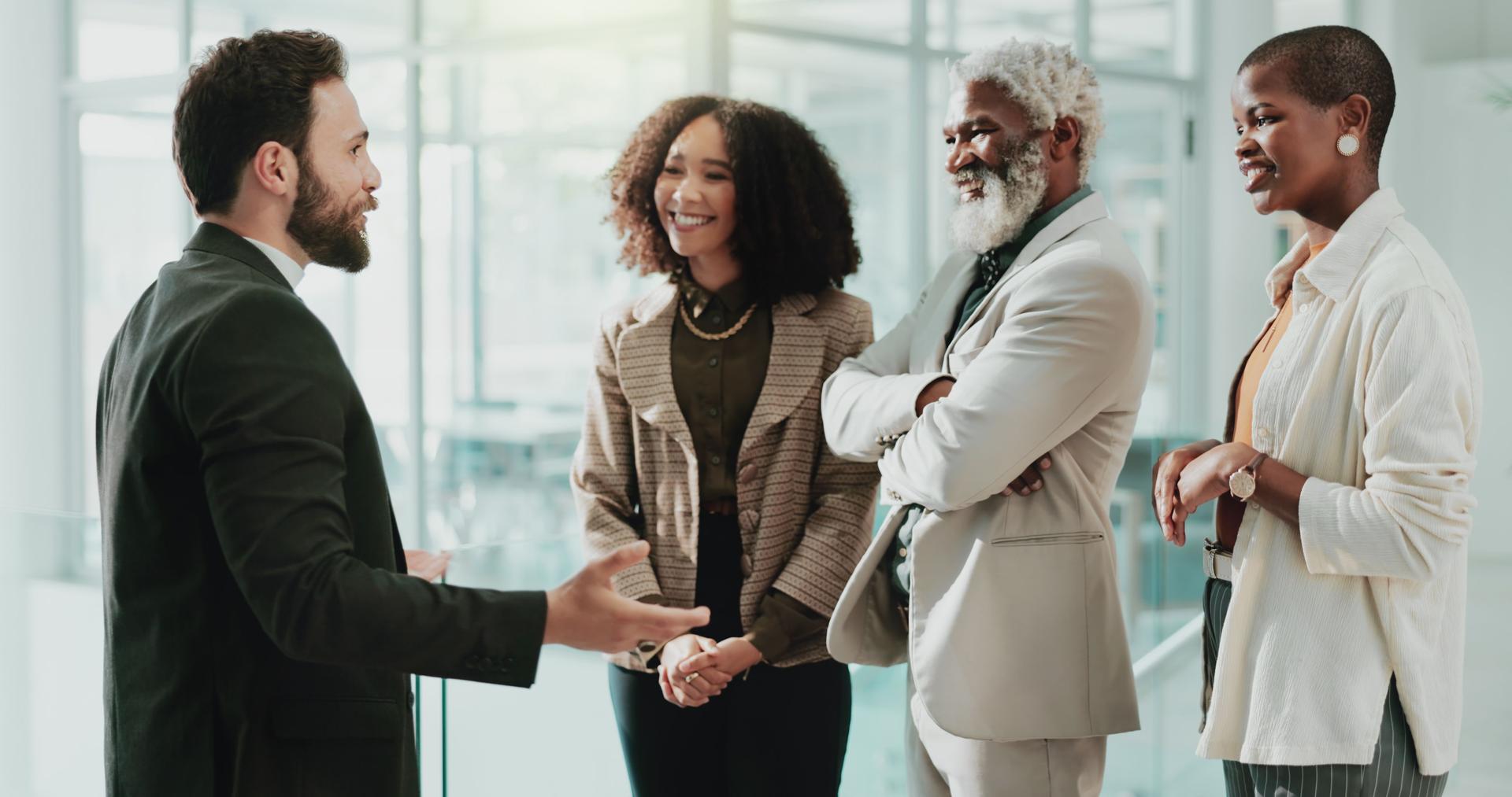 Collaboration, meeting and welcome with business people in office for introduction or orientation. Conversation, diversity and explain with happy employee group in corporate workplace for discussion
